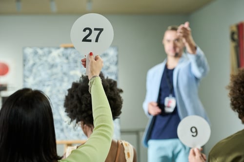 Someone holding a bidding card during an auction